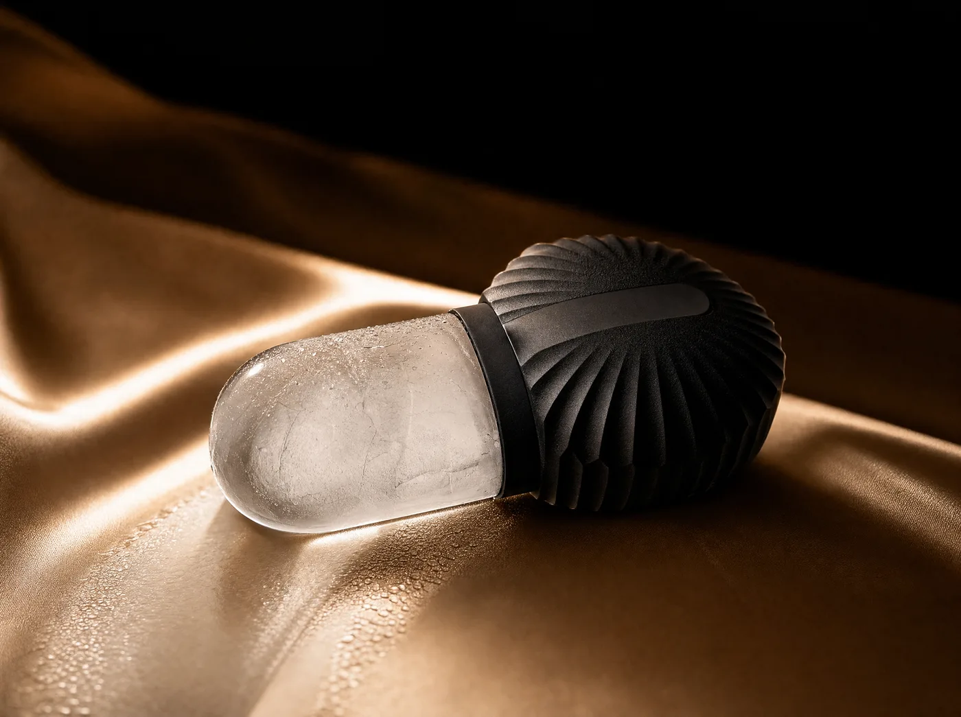A stainless ice roller gliding in one slow pass along a cheek