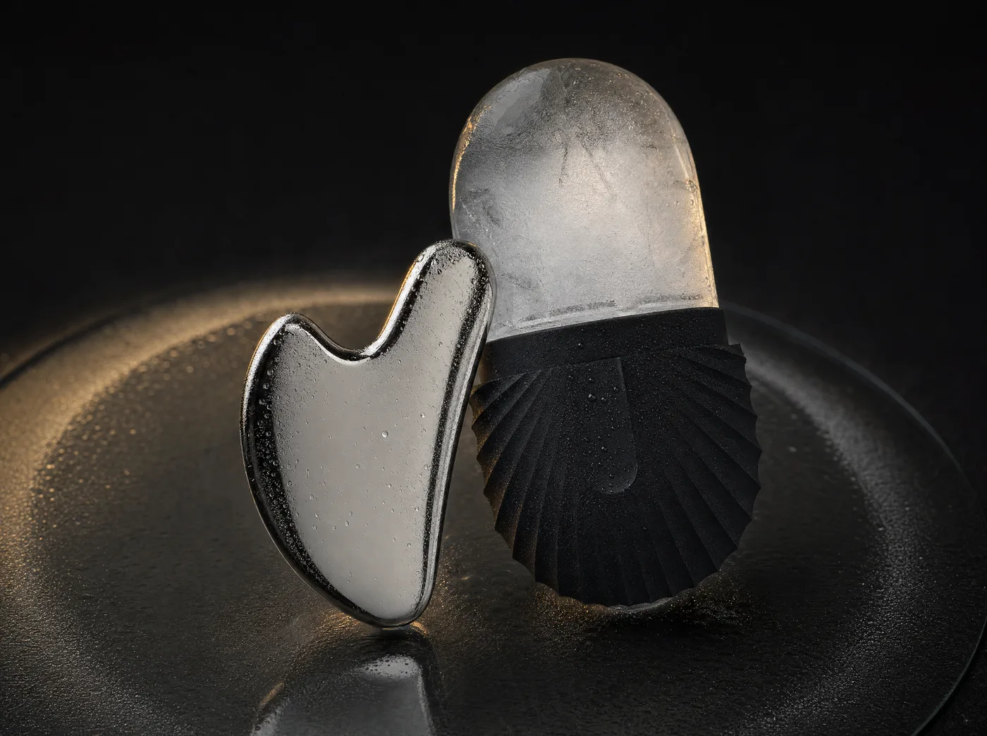 The CryoSteel Duo's roller and heart-shaped tool crossed on smoked glass