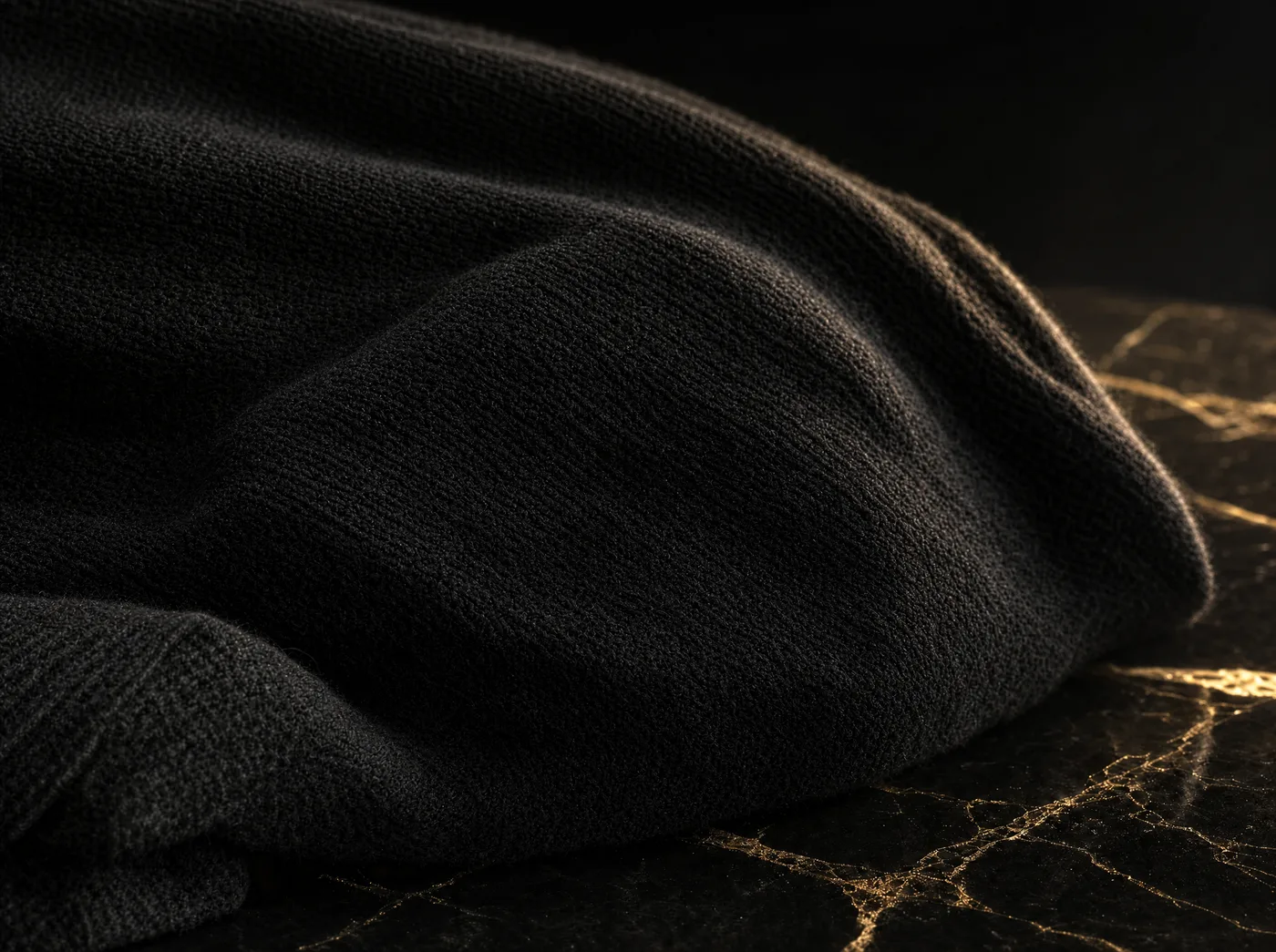 The same black knit after a controlled pass, the entire surface visibly smoother and cleaner with the fine knit texture intact